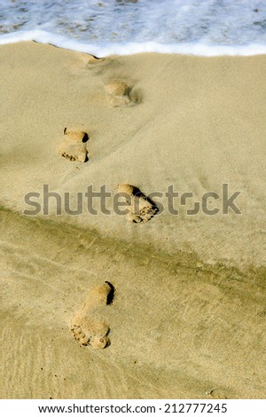 human footprints on the coastline sand.