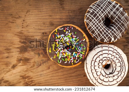 Bright donuts on wooden background.