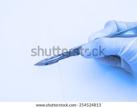 hand with scalpel on blue filter
