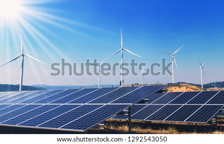 concept clean energy power in nature. solar panels and wind turbine on hill