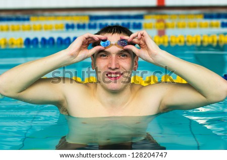 Male swimmer getting ready for laps in indoor pool.