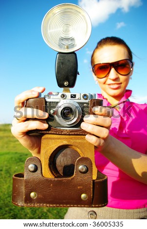 Young woman with old camera outdoor.