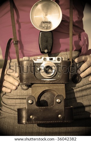 Young woman with old camera outdoor. Retro style.