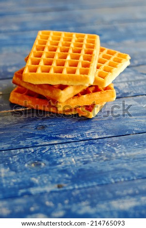 Golden squared waffles on a blue wooden table