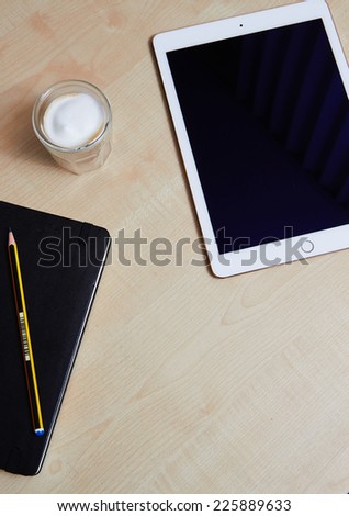 Top views showing iPad Air 2 with touch id on wooden desk and a coffee