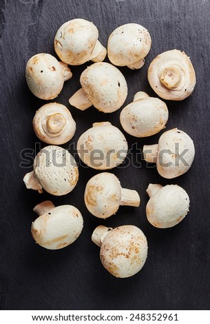 Fresh cup mushrooms on a black slate ready to cook