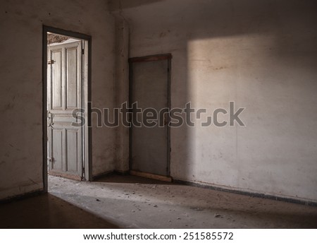 Sunlight is falling through an empty room of an old, deserted building.