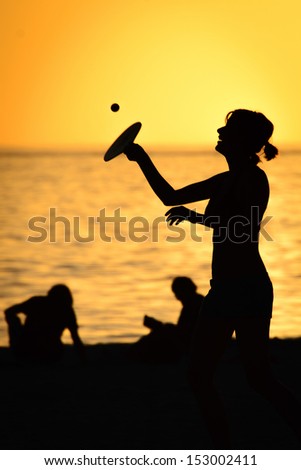 Silhouette of a woman playing paddle ball on the beach, Fort Myers, Lee County, Florida, USA