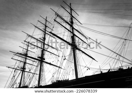 An old wooden sailing tea clipper with a view of the masts and rigging. A black and white image.Clear outline of the masts and rigging against the sky.