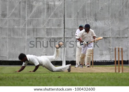 KUALA LUMPUR, MALAYSIA - MARCH 3 : Unidentified bowler tries to catch the ball during a friendly match between Royal Selangor Club and Silver State Cricket Club on March 3,1012 in K. Lumpur, Malaysia