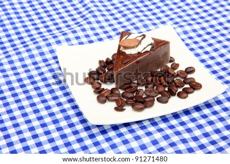 Coffee cake with whole coffee bean decoration on picnic table cloth background
