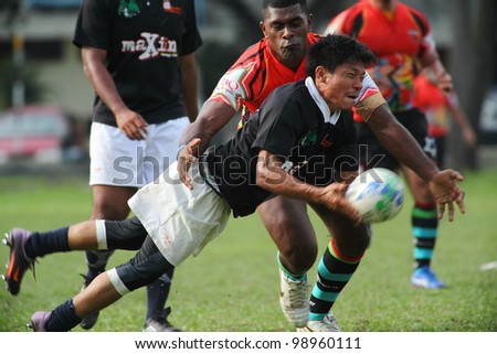 KUALA LUMPUR-MARCH 31:Unidentified Bandaraya Dragons player try to pass during a Malaysian Rugby Union Super League match versus Keris Conlay on March 31,2012 in Kuala Lumpur,Malaysia.Conlay won 21-15