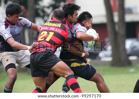 KUALA LUMPUR-MARCH 31: Two unidentified SAHOCA players try to tackle an UiTM Lions player during a Malaysian Rugby Union Super League 2012 match (UiTM Lions vs SAHOCA) on March 31, 2012 in Kuala Lumpur, Malaysia