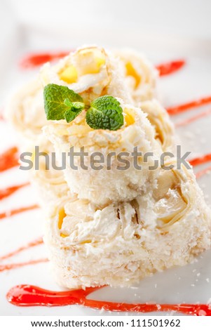 Dessert Maki Sushi - Roll with Banana and Cream Cheese inside. Pancake with Coconut outside. Served with Berries Sauce