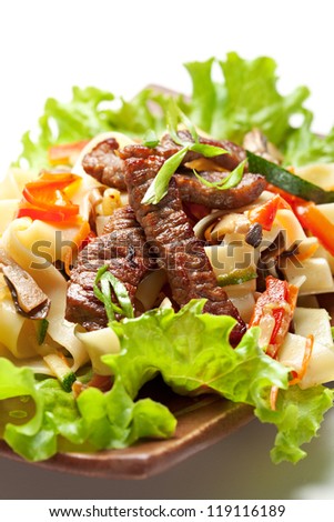 Fried Noodles with Beef and Vegetables. Garnished on Salad Leaf