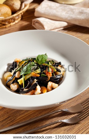 Black Pasta with Seafood and Vegetables. Garnished with Basil Leaf