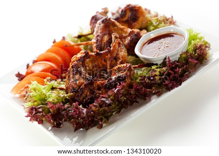 Hot Meat Dishes - Fried Chicken Wings with Salad Leaves, Tomatoes and Spicy Sauce