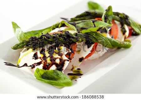 Caprese Salad - Salad with Tomatoes, Mozzarella Cheese, Asparagus, Balsamic. Salad Dressing with Pesto Sauce