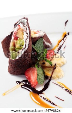 Chocolate Pancakes with Fruit Wrap. Served with Chocolate and Caramel Sauce. Isolated on White Background