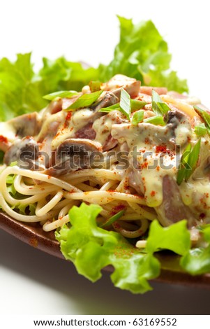 Noodles with Meat and Mushrooms and Cheese Sauce. Garnished on Salad Leaf
