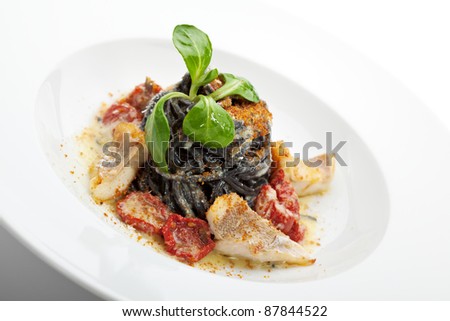 Black Spaghetti with Sea Bass and Batarga (dried, salted, pressed red roe) and Dried Cherry Tomato. Served with Fresh Corn Salad Leaves