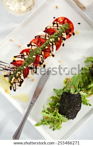 Caprese Salad - Salad with Tomatoes, Mozzarella Cheese, Balsamic. Salad Dressing with Pesto Sauce and Rocket Salad