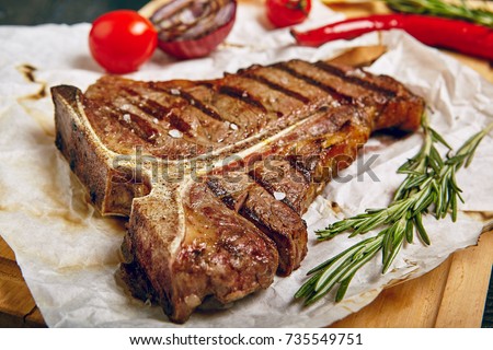 Gourmet Grill Restaurant Steak Menu - T-Bone Beef Steak on Wooden Background. Black Angus Prime Beef Steak. Beef Steak Dinner