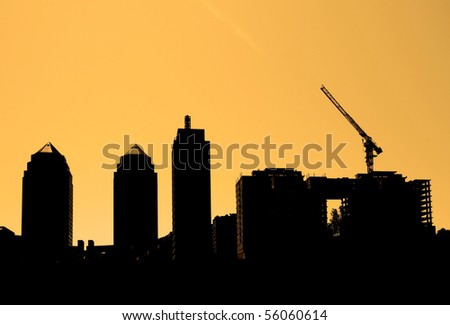 Construction. Silhouettes of many-storeyed houses, the building crane against the sky