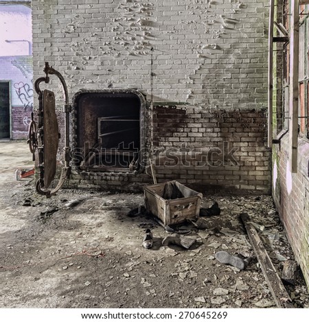 This photo was taken looking inside the laundry building of the former Foxboro State Hospital.   This looks more like a crematorium than a cloths drier.