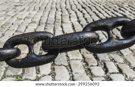 Chain links over cobble stone side walk located in the North End of Boston, MA