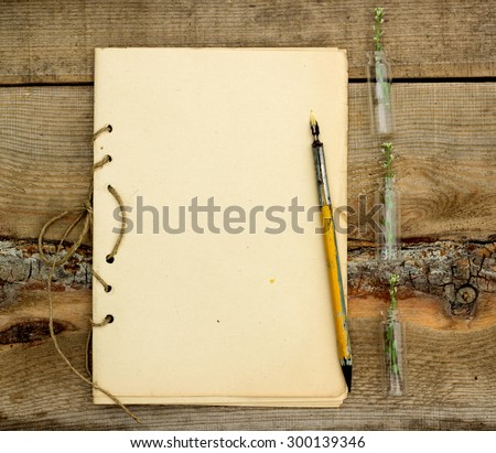 handmade notebook with old pen on a wooden background