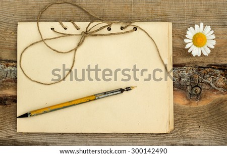 handmade notebook with old shabby pen on a wooden background