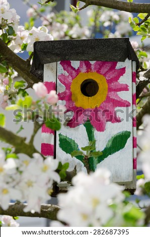 Home Sweet Home\
Bird house on an apple tree\
A birdhouse is used by certain animals to bring up their brood or offsprings.