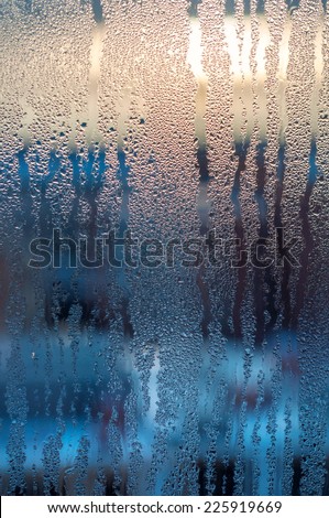 Frozen water droplets on glass, lit by the rays of the sun
