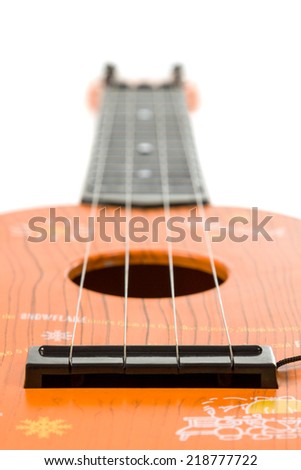 Children\'s guitar with four strings of red color isolated on white background