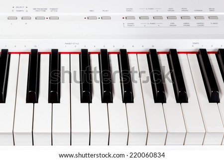 Keys of white electric music synthesizer with a set of buttons