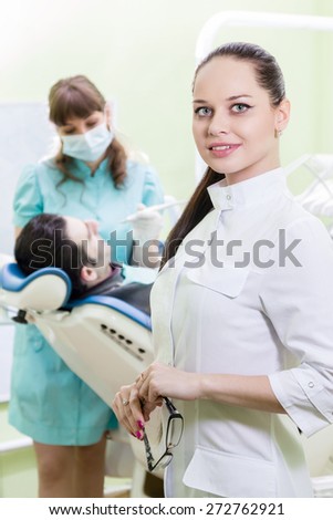 Portrait of dentist in the background of a dental clinic where the doctor treats her patient