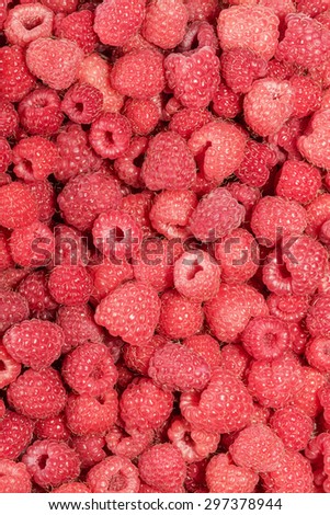 Background vertical orientation of fresh red raspberries