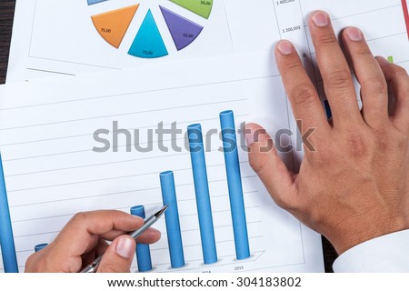 Hand of businessman showing the pen on the chart