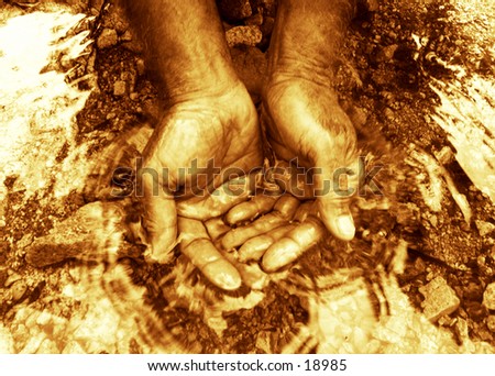 A man\'s hands cupping pure clean water. Golden color toned black and white image.