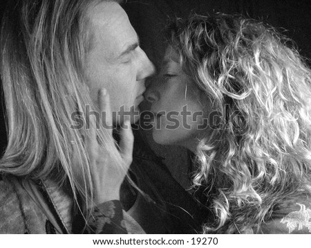A man and a woman totally in love embrace. Sexy kiss. soft romantic image in a grainy black and white style.