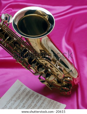 Saxophone and sheet of music on sexy pink satin.