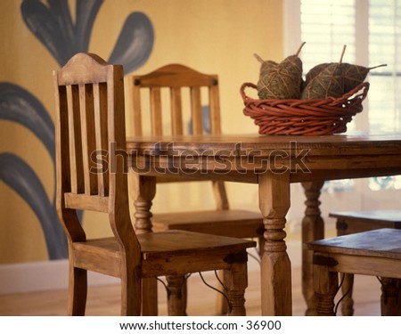 Contemproary dining room with a mural and woven pears on the table.