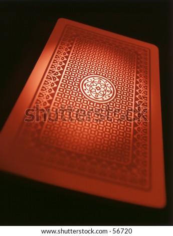 A single red playing card lit with red in the shadow area and white hightlights.