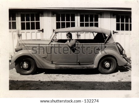Vintage photo of a young man in a car. Circa 1937