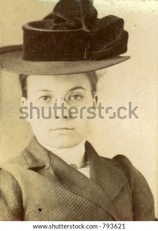 Vintage print of a young woman in a stylish hat. Circa 1910 print has scratches, artifacts, fading and solarization qualities.