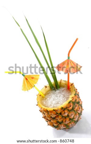 Natural Pineapple hollowed out and filled with an icy drink and tropical umbrellas isolated on a white background.