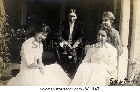 A dashing young man enjoys the attention of several young ladies.  Original Circa 1911 print has scratches, artifacts, fading and solarization qualities.