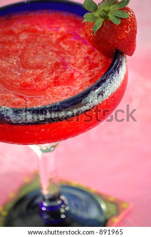 Strawberry margarita with sugar rimmed glass on pink background. Shallow depth of focus.