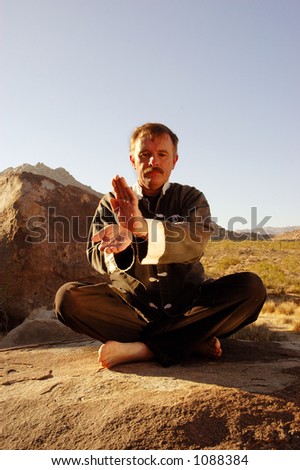 Man practicing Tai Chi meditation in the desert.